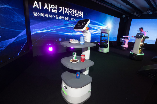ㅗKT관계자가 AI 사업 기자 간담회에서 AI를 기반으로 작동하는 음식 서비스 로봇을 시연해 보이고 있다. [사진=KT]