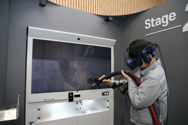 한화오션 거제사업장 내부에 위치한 VR 도장교육센터에서 직원이 새롭게 개발된 '리얼 블라스트'를 통해 VR 블라스팅 직무훈련을 하고 있다. [사진=한화오션]
