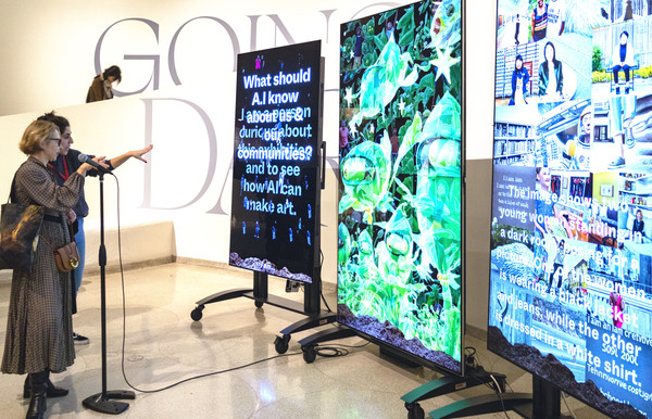 관람객들이 구겐하임 미술관에서 올레드 화면(왼쪽)을 통해 질문하면 AI가 마이크로 대답하며 소통하는 전시를 체험하고 있다. [사진=LG전자]