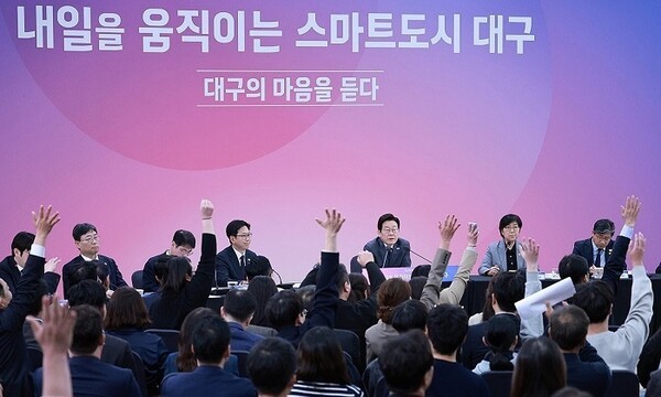 24일 대구 엑스코에서 열린 ‘대구의 마음을 듣다’ 타운홀미팅에서 참석자들이 이재명 대통령을 향해 손을 들며 발언권을 요청하고 있다. [사진=대통령실통신사진기자단/연합뉴스]
