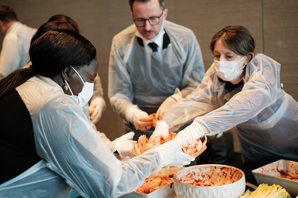 지난 21일 열린 롯데호텔앤리조트의 ‘김치의 날 외교 오찬행사’에서 각국 대사들이 김장 체험을 하고 있다. [사진=롯데호텔앤리조트]